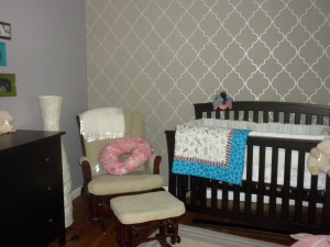 Glider and crib in completed baby girl nursery